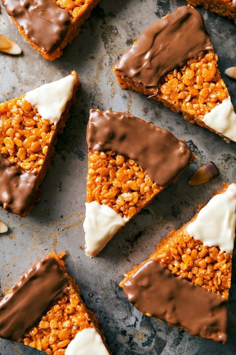 HALLOWEEN CANDY CORN KRISPIE TREATS! The absolute best peanut butter krispie treats decorated to look like candy corns with melted white and milk chocolate topping! Recipe via chelseasmessyapron.com