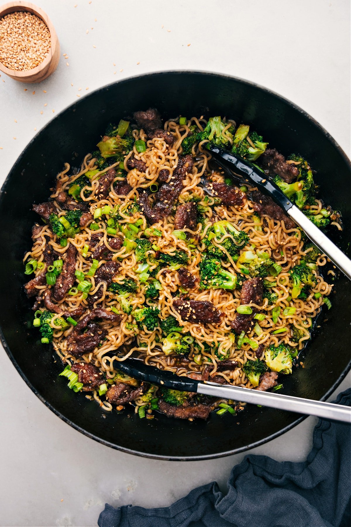 The Best Beef And Broccoli Ramen Recipe Beef and Broccoli Ramen in a pot, tongs ready to serve.