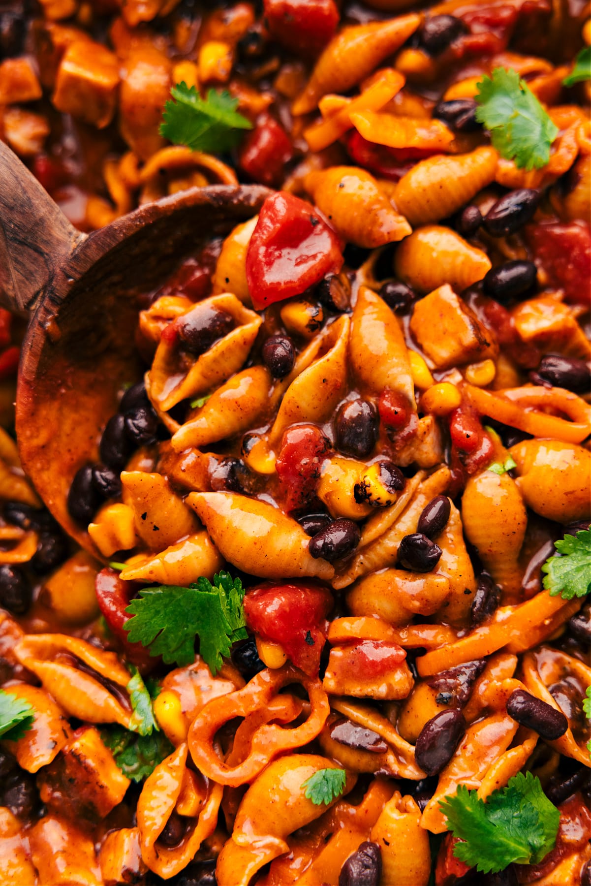 The enchilada pasta in the pot with a spoonful being scooped out.