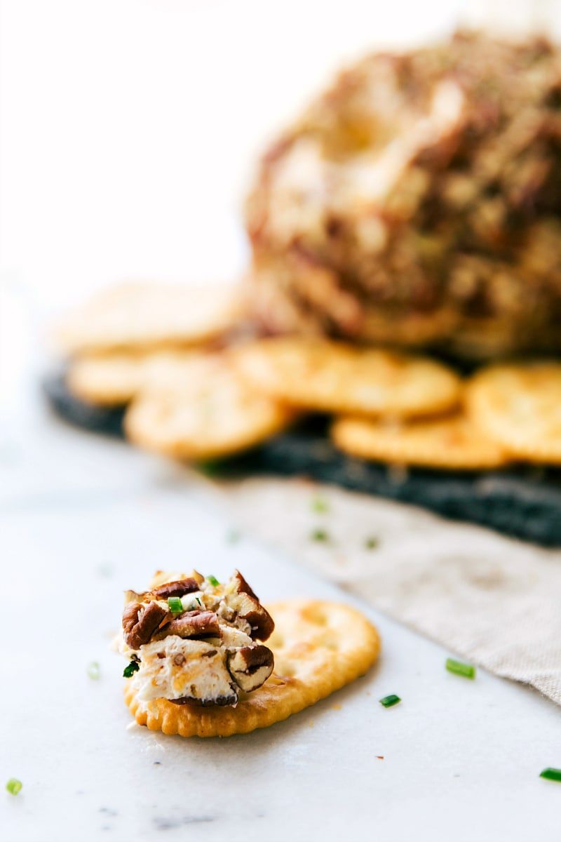 Image of a bit of the Cheese Ball on a cracker, ready to be eaten.