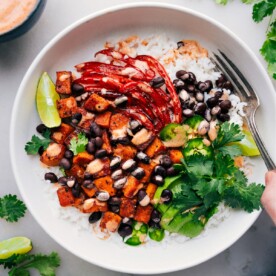 Sweet Potato & Black Bean Burrito Bowls with dressing drizzled over it.