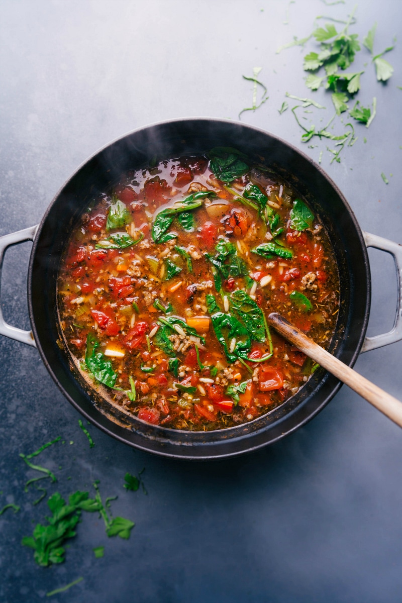 Warm and hearty italian sausage orzo soup in a pot, steaming and ready to be enjoyed.