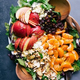 Mandarin orange salad on a large platter, adorned with sliced fruit, presenting a healthy and vibrant dish.