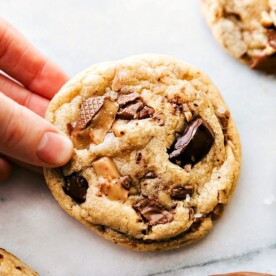 Freshly baked toffee cookies held in hand, still warm and ready to be savored.