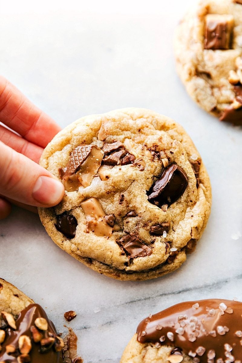 Overhead image of a Toffee Cookies fresh out of the oven being held ready to be eaten.