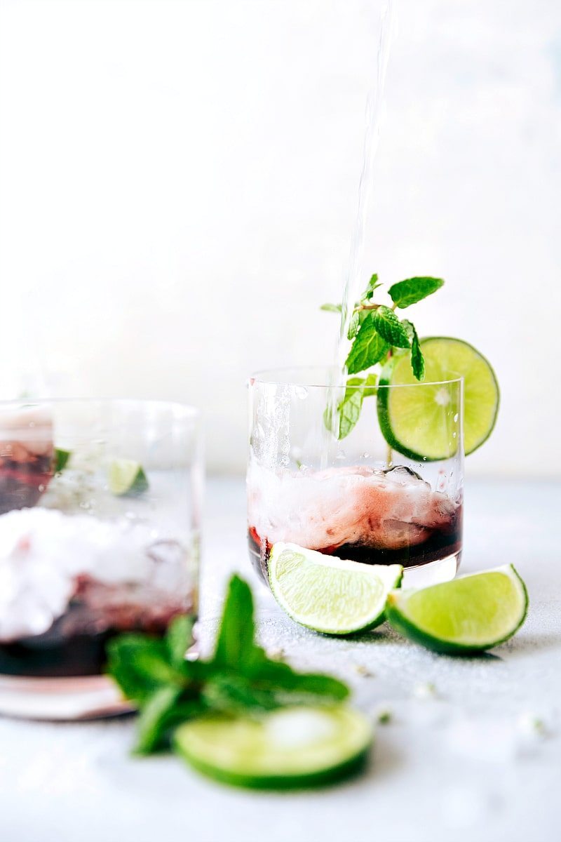 View of several glasses of Tart Cherry Spritzer with lime wedges