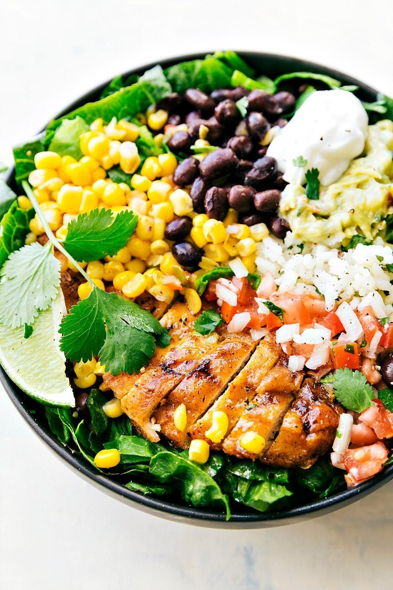 EASY MEAL PREP Chicken Burrito Bowls! Tons of short-cuts for a better than a restaurant chicken burrito bowl! Taco-seasoned chicken, cilantro-lime rice, salsa, guac, beans, and a creamy cilantro sauce! Recipe from chelseasmessyapron.com