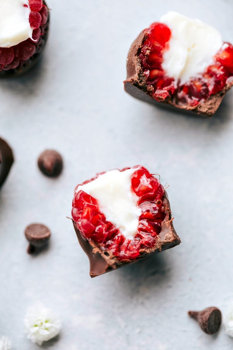 Chocolate-Covered Raspberries are so fancy looking, but couldn’t be simpler to make! These pop-able treats are rich and chocolatey with a bright and sweet raspberry center. Recipe via ChelseasMessyApron #dessert #best #quick #easy #simple #treat #valentines #cheesecake #stuffed #raspberries Overhead image of the cheesecake-stuffed raspberries