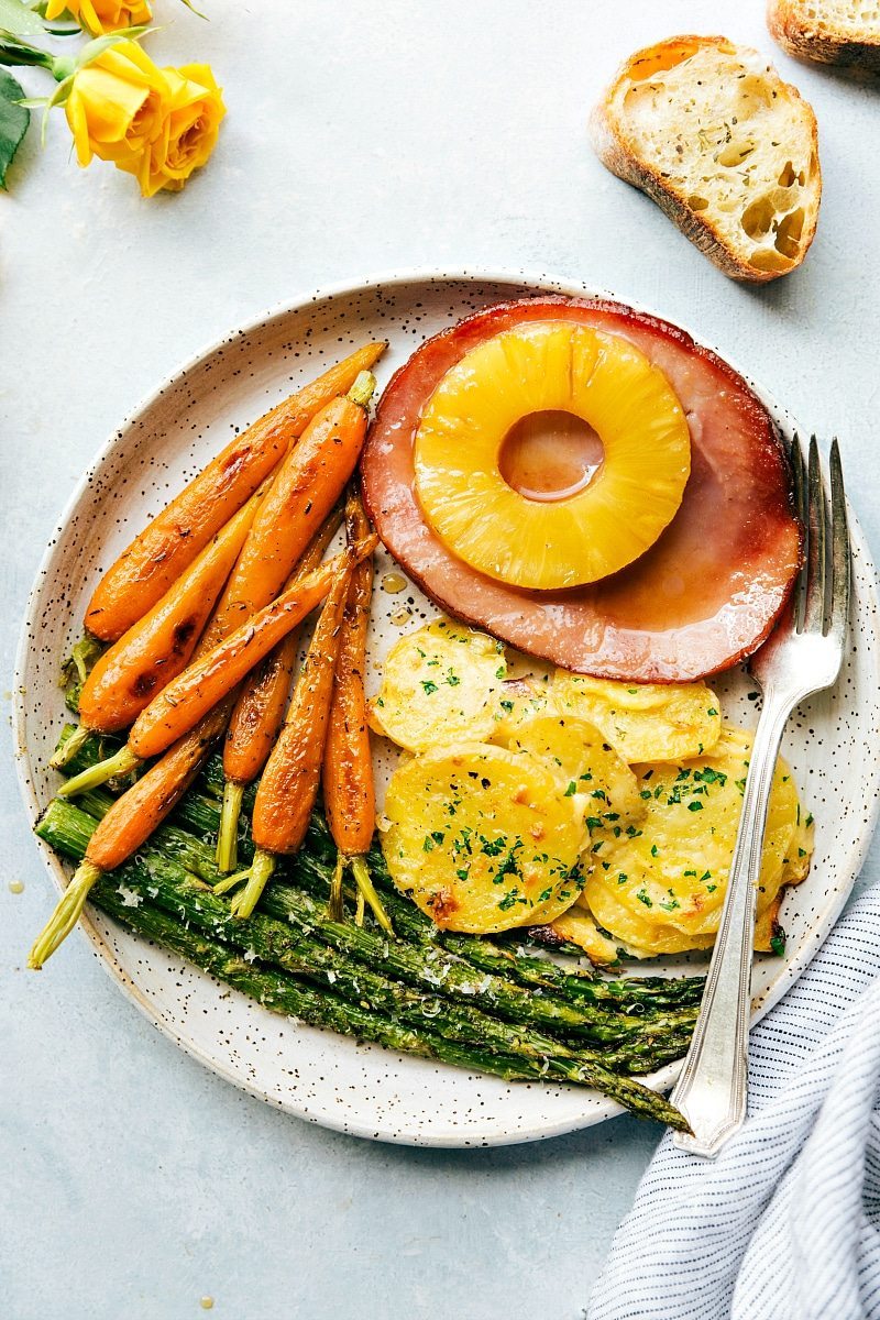 A plateful of easter dinner ideas- ham, carrots, potatoes, and asparagus 