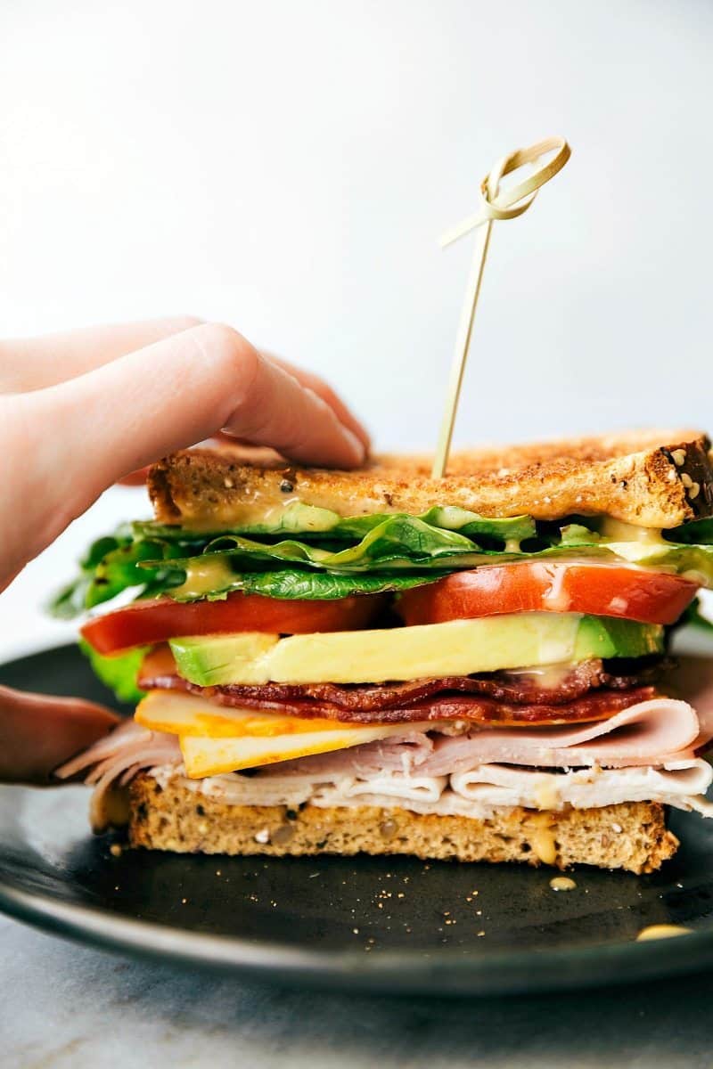 Honey Bacon Clubs -- toasted bread, crisp fresh veggies, smoked turkey, honey ham, center-cut bacon, muenster cheese, and the most incredible SECRET INGREDIENT honey mustard spread! via chelseasmessyapron.com