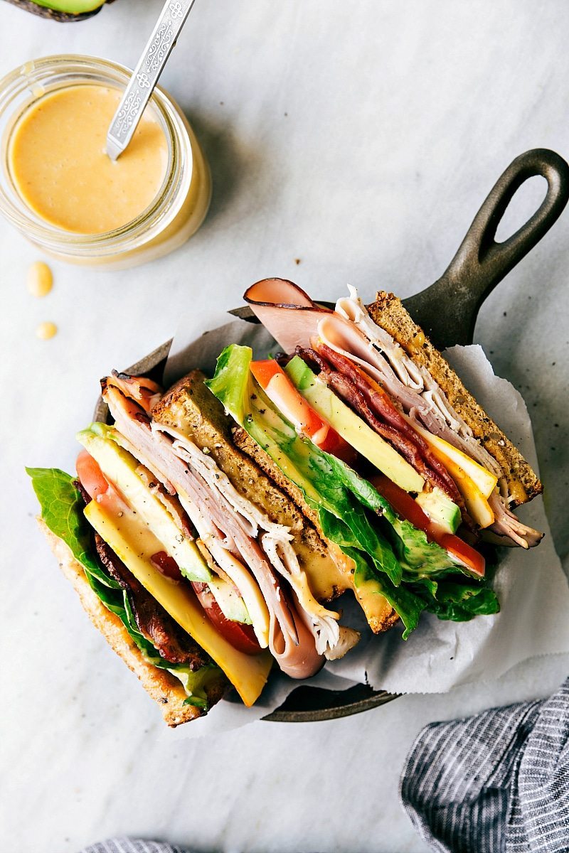 Honey Bacon Clubs -- toasted bread, crisp fresh veggies, smoked turkey, honey ham, center-cut bacon, muenster cheese, and the most incredible SECRET INGREDIENT honey mustard spread! via chelseasmessyapron.com