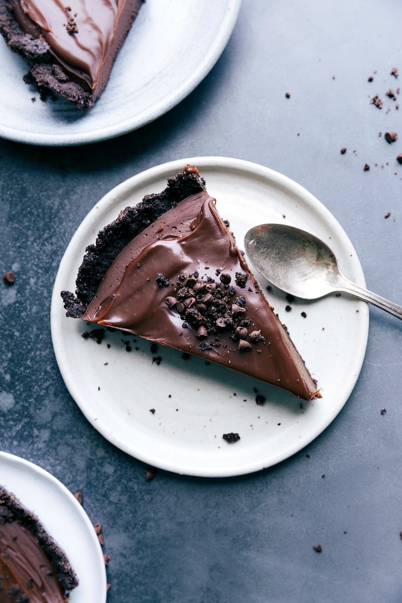 A slice of chocolate tart, a mouthwatering dessert topped with oreo crumbs, ready to be savored.