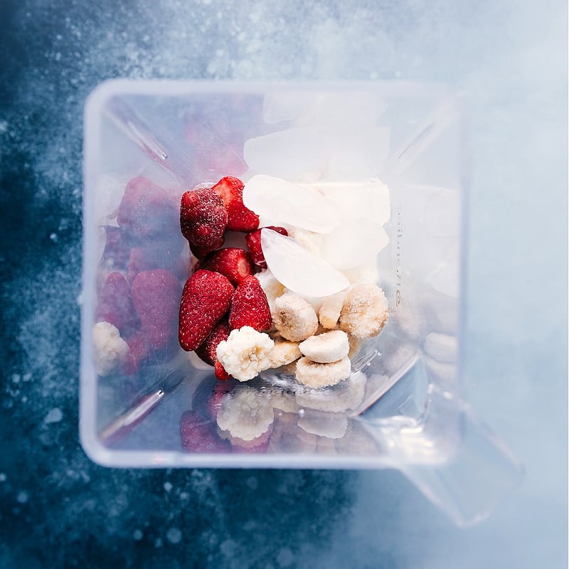 Overhead view of smoothie ingredients in a blender.