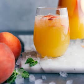 Delicious and refreshing peach lemonade with sliced peaches used for garnish.