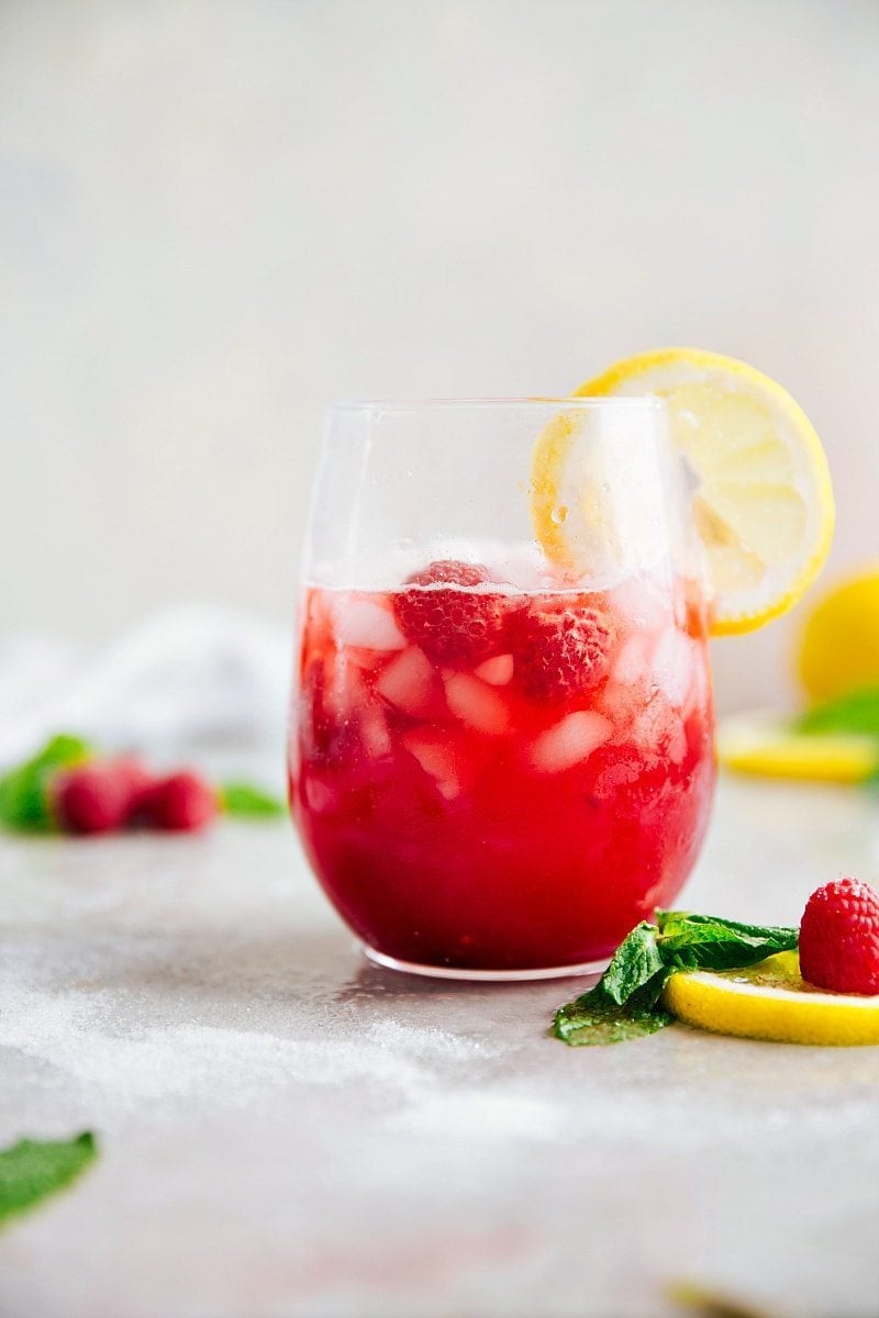 Image of the ready to drink raspberry lemonade with a lemon slice on the side and ice in it