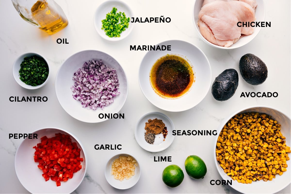 Ingredients In Summer Chicken Recipe All the ingredients for this recipe are prepped and ready for easy assembly, including the meat, jalapeño, marinade, onion, seasonings, corn, lime, garlic, pepper, cilantro, and oil.