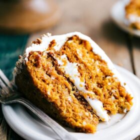 Slice of pumpkin carrot cake revealing its soft and moist interior, topped with a delicious icing.
