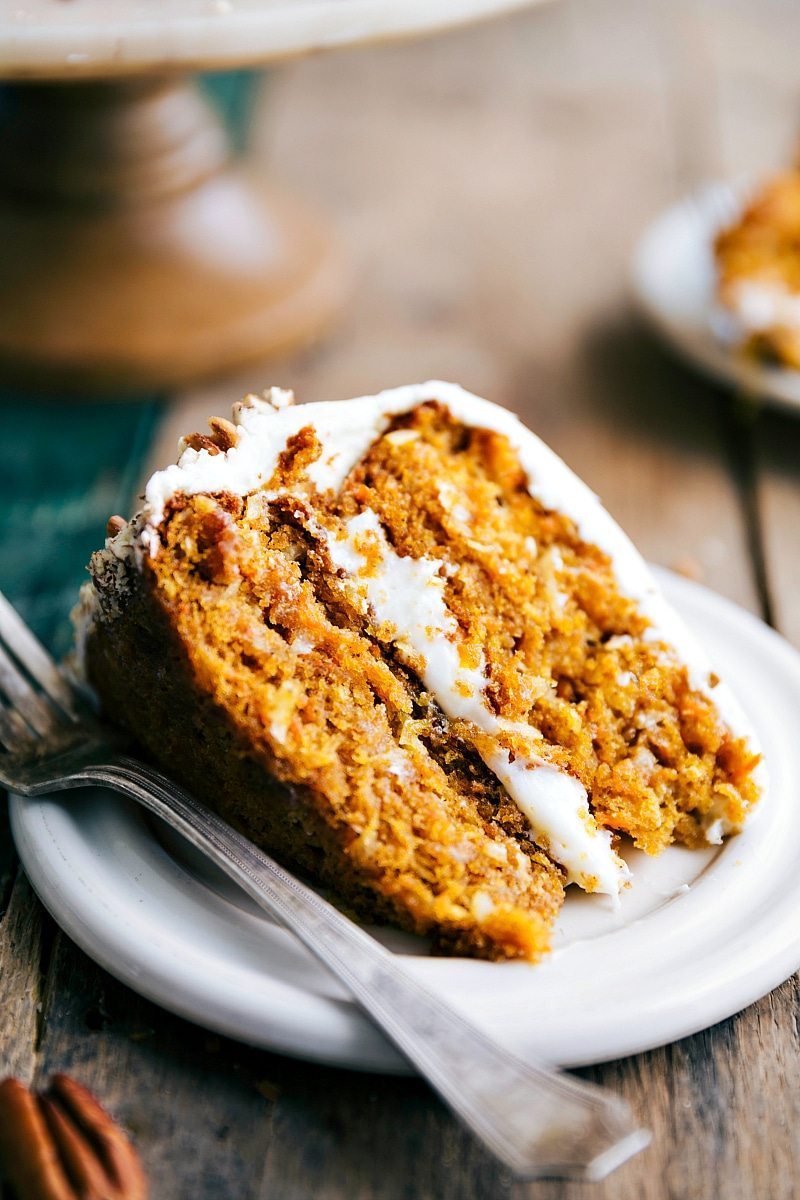 Slice of pumpkin carrot cake revealing its soft and moist interior, topped with a delicious icing.