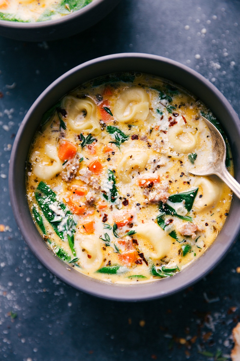 Up-close overhead image of the Sausage Tortellini Soup in a bowl with a spoon in it.