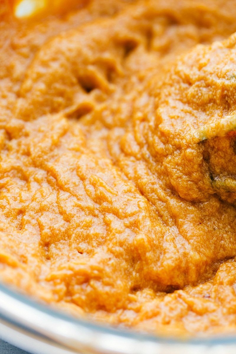 Canned pumpkin being added to the batter mixture.