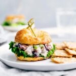 Savory chicken salad sandwich on a plate, with a generous filling visible between the bread slices.