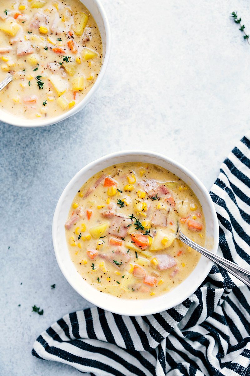 Two bowls of steaming ham and potato soup, rich and hearty, ready for consumption.