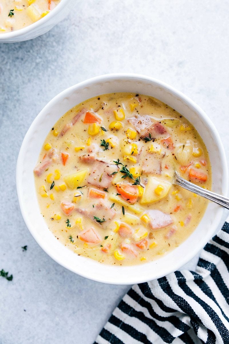 A hearty, inviting bowl of potato and ham soup, steaming and ready to be enjoyed.