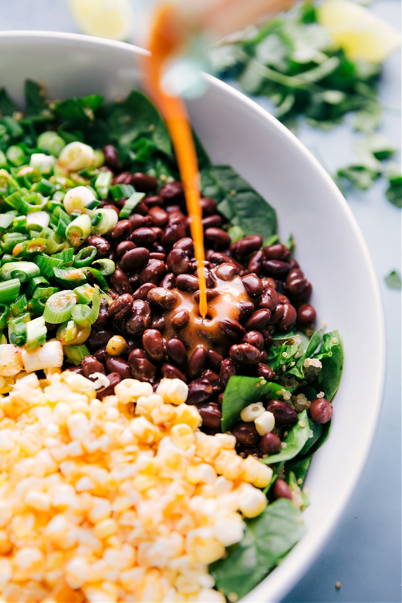 View of the chipotle-lime dressing being poured over the salad.