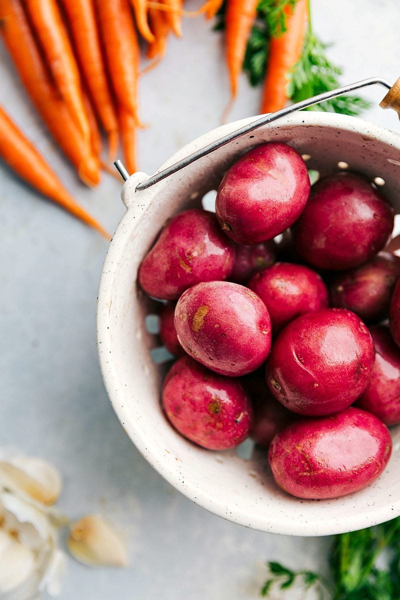 overhead photo of red potatoes, carrots, and garlic for this one