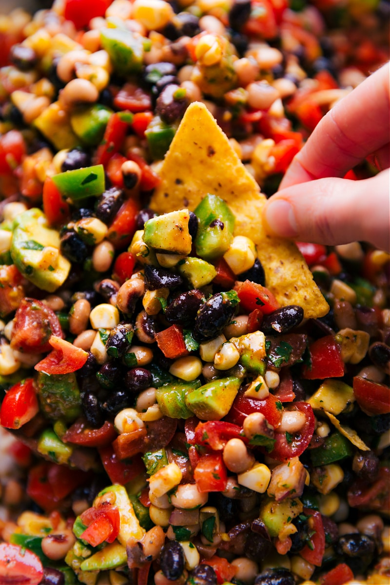 Close-up view of a chip being dipped in Cowboy Caviar.