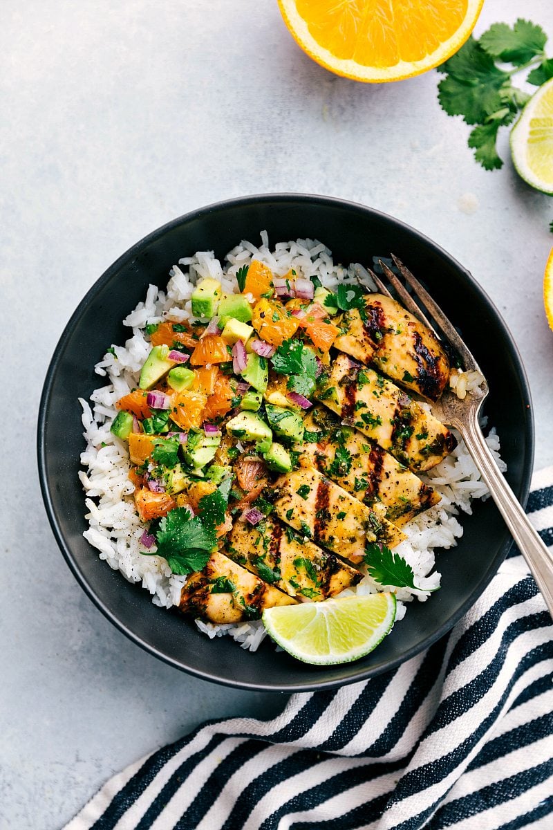 Bowl of cuban mojo chicken with an avocado citrus salsa served over cilantro lime rice