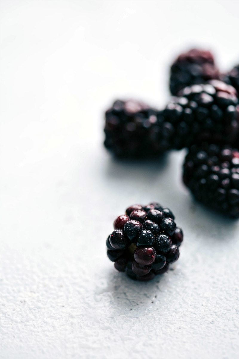 Up-close macro shot of blackberries -- one in focus and several out of focus. These blackberries go in the lemonade.