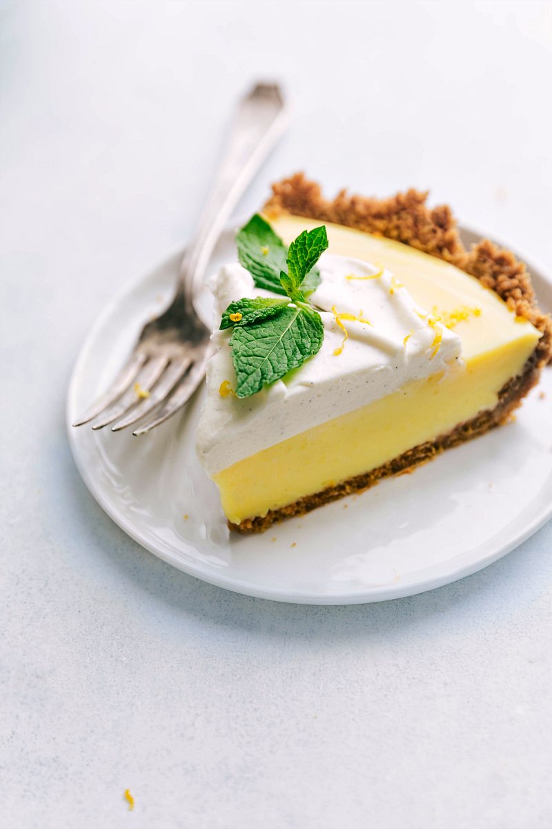 Slice of Lemon Pie recipe on a plate with fresh mint on top.