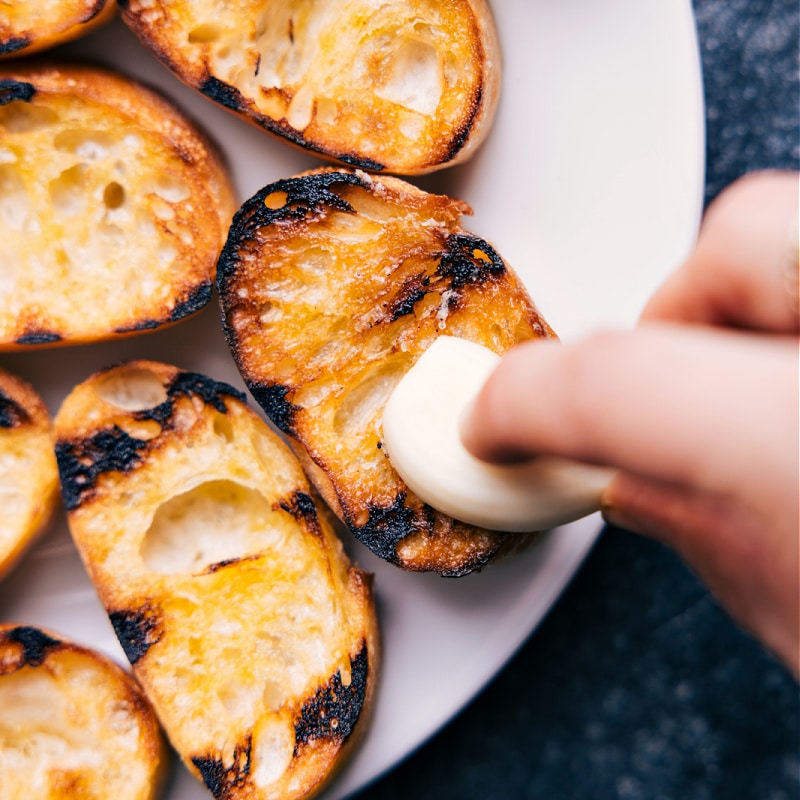 Process shots of Bruschetta- image of the garlic being spread over the bread