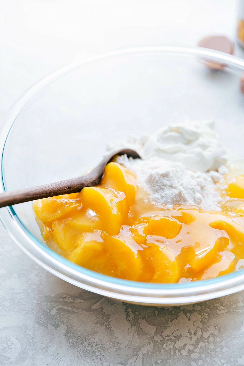 The cake mix and peach pie filling being mixed together in a bowl for this peaches and cream cake.