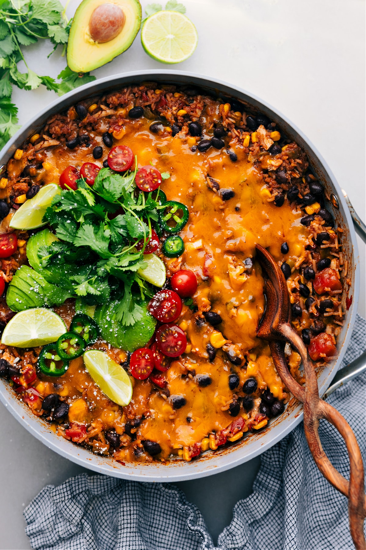 One-Pot Burrito Bowls in the skillet garnished with avocado, cilantro, lemon and tomatoes.