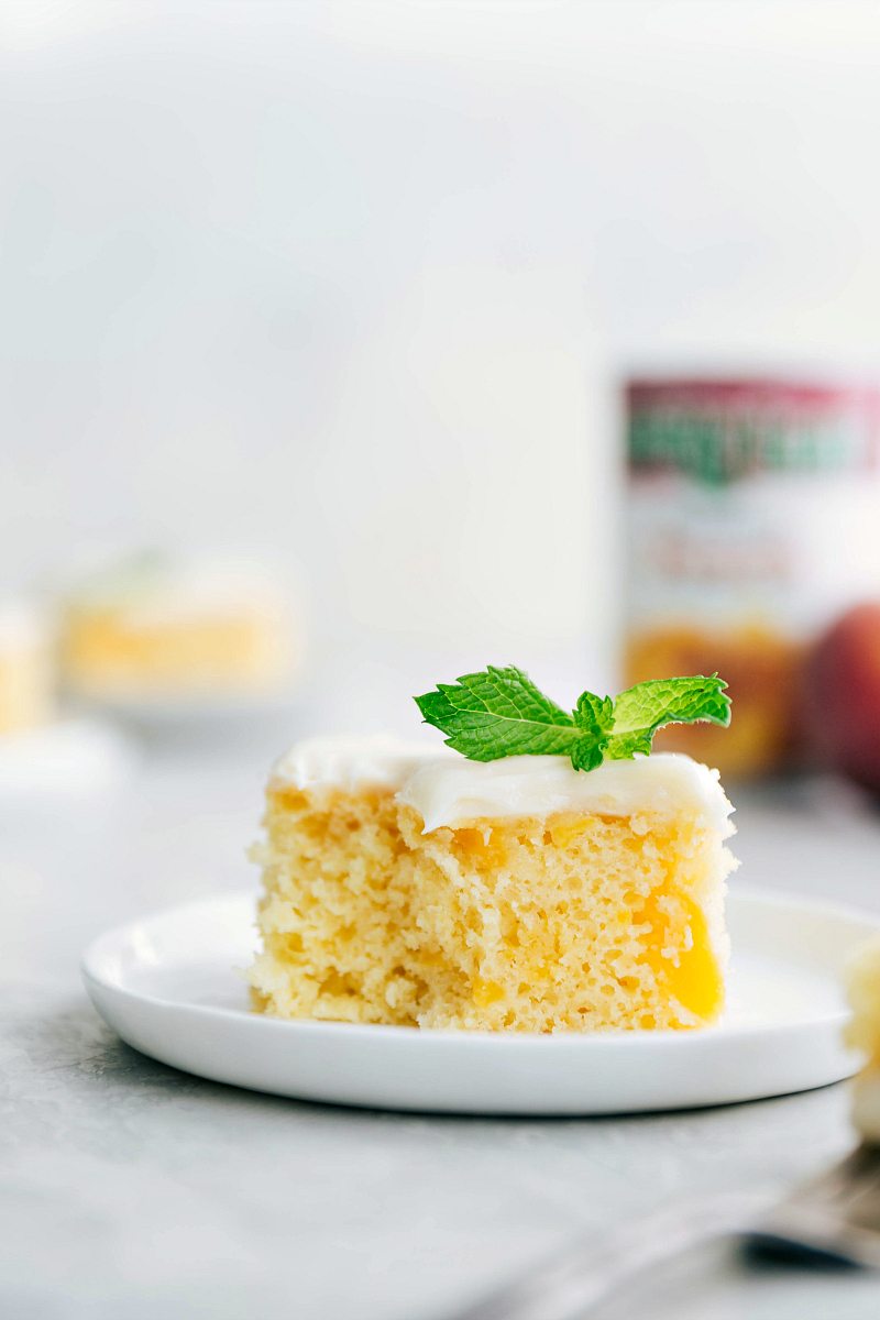 Peaches and cream cake on a plate with a bite out of it.