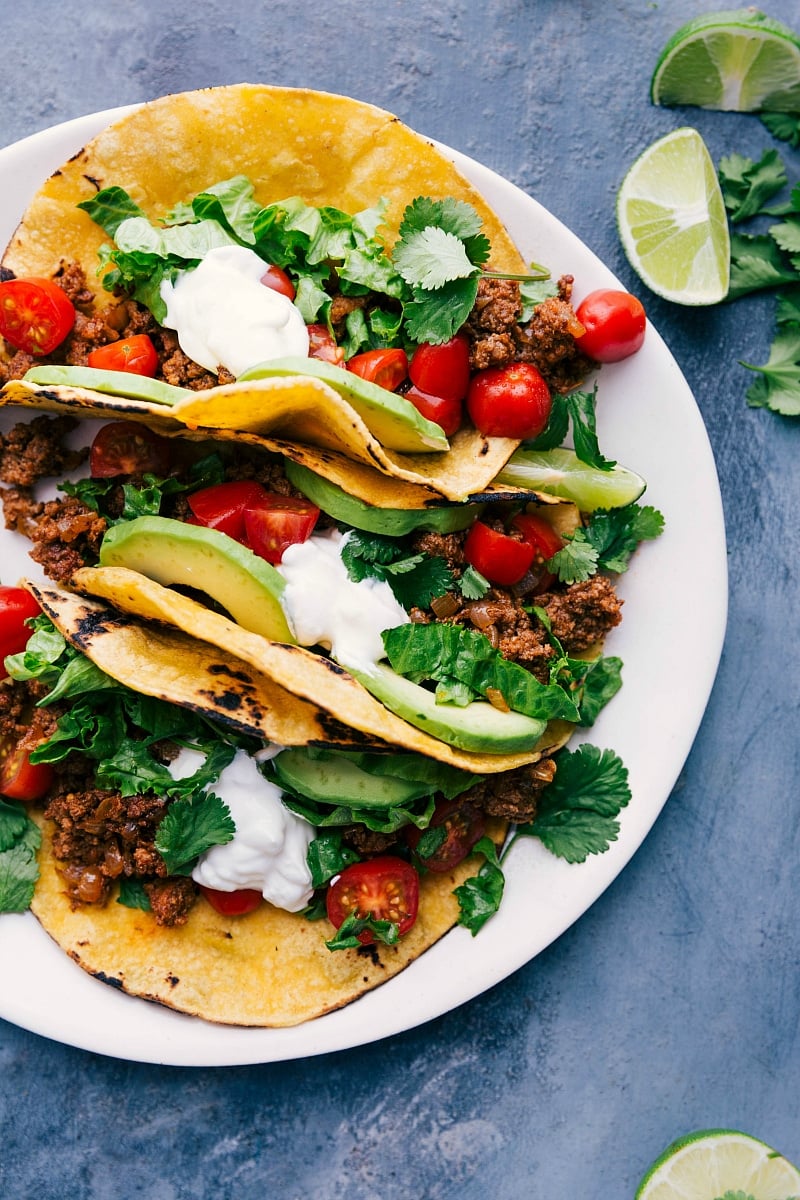 Overhead image of Turkey Tacos on a plate with toppings an.d fresh lime wedges on the side