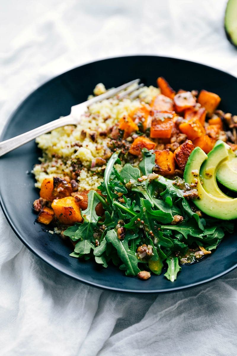 Side angle view of a plate with the perfect roasted butternut squash, couscous, and the best dressing! A perfect healthy Fall meal