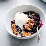 Blueberry Crisp in a bowl, topped with ice cream.