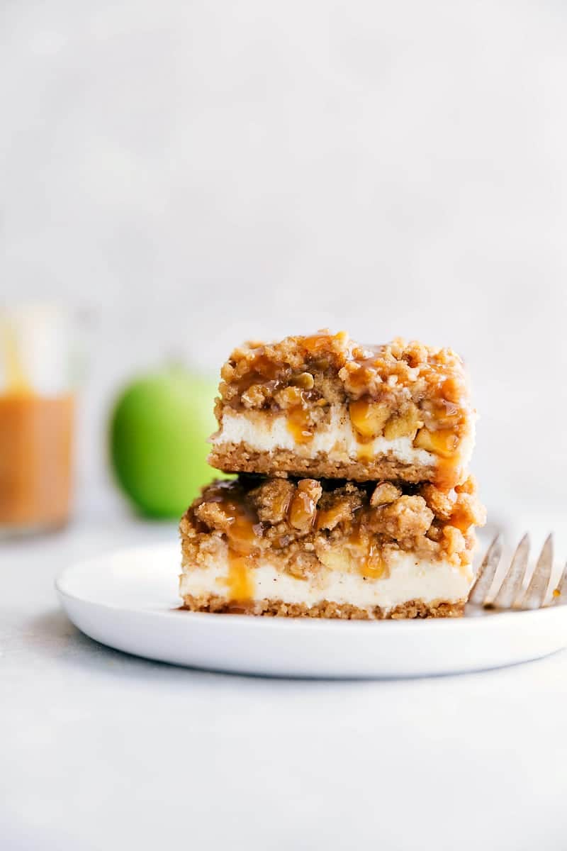 A stack of caramel apple cheesecake bars with mouth-watering layers.