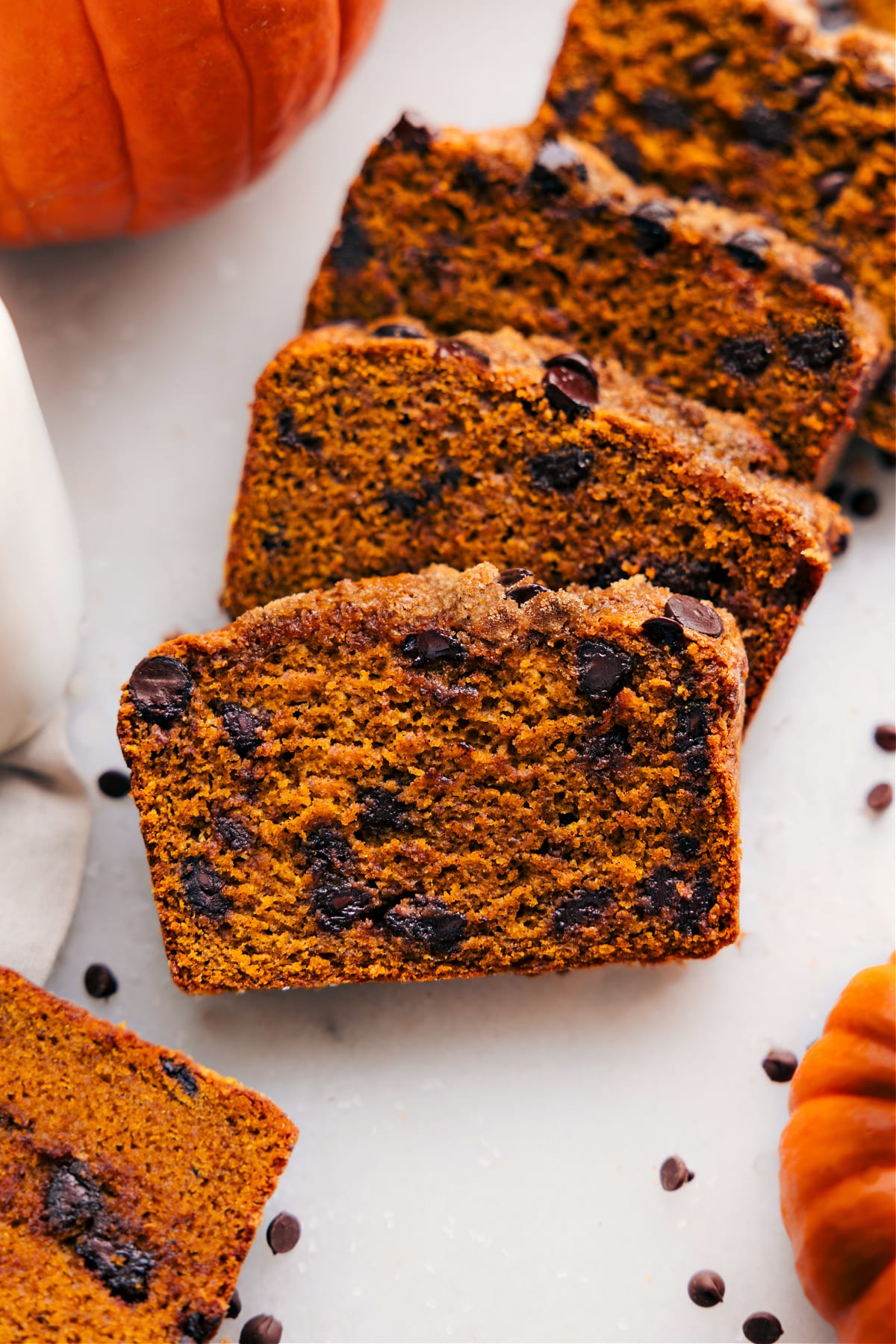 Moist and flavorful healthy pumpkin bread slice, packed with nutritious ingredients and fall spices, displayed on a white backdrop.