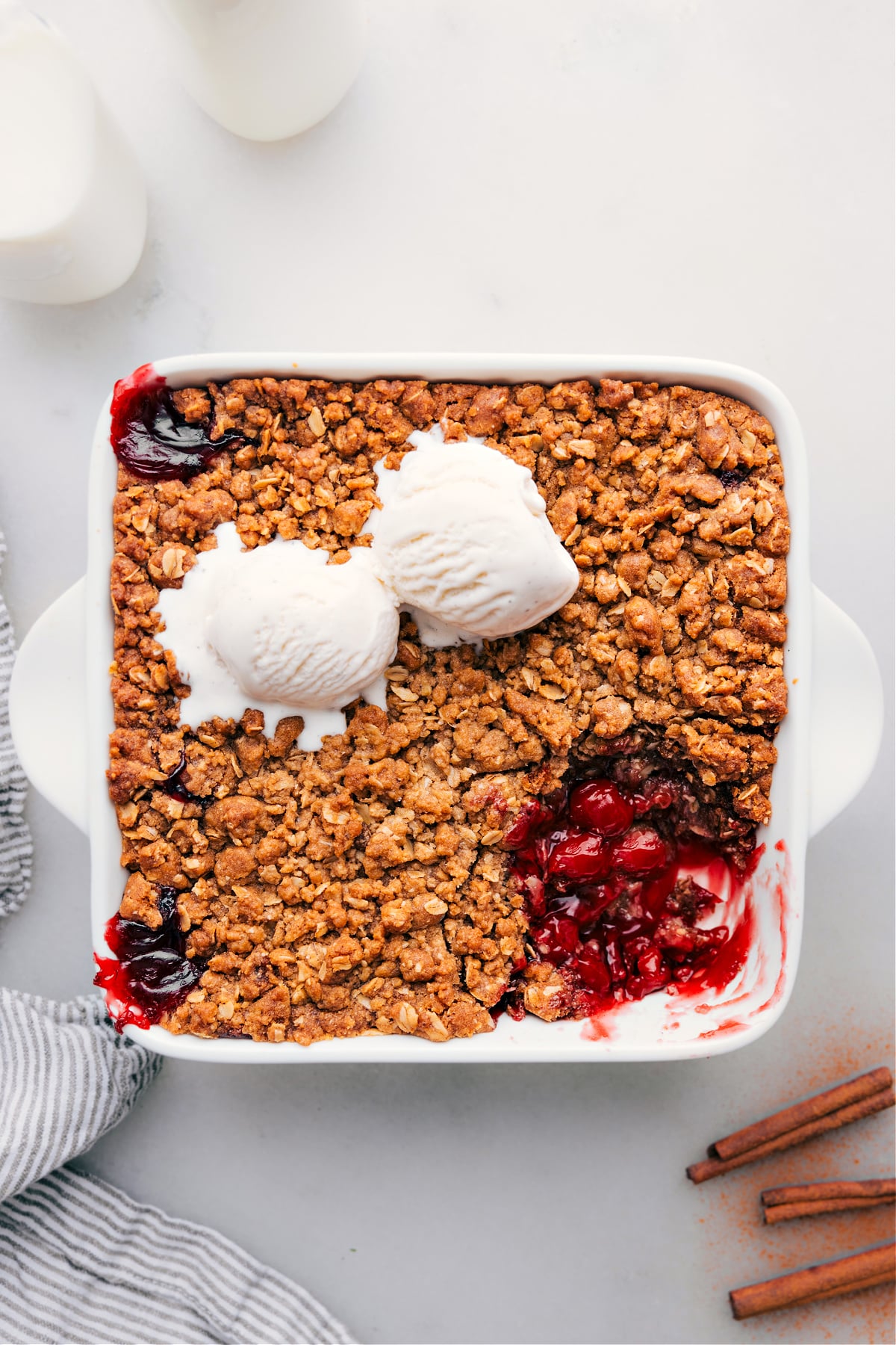 Cherry crisp in a pan with a scoop removed, revealing its delectable contents.