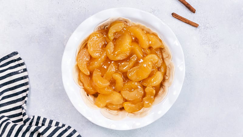 Process shot-- image of the apple filling being added to the crust 