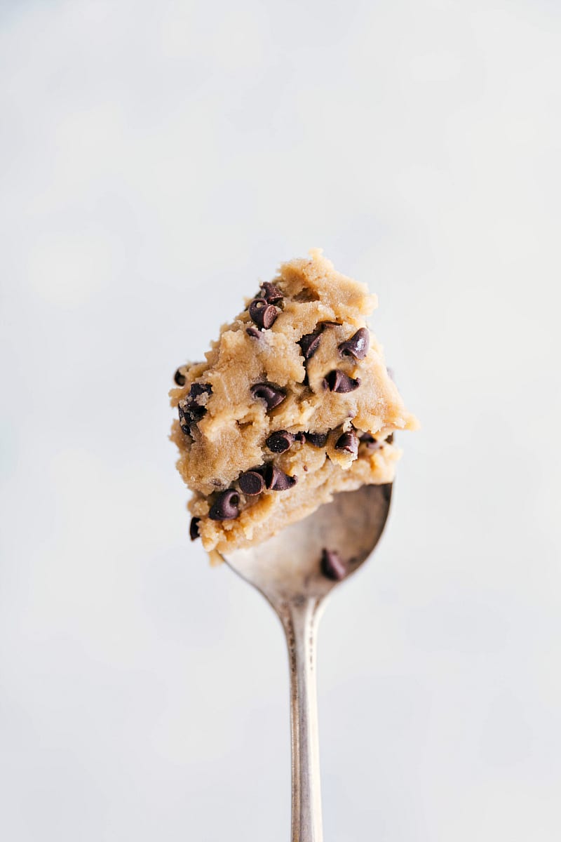 A generous scoop of edible chocolate chip cookie dough sitting temptingly on a spoon, ready to be enjoyed without baking.