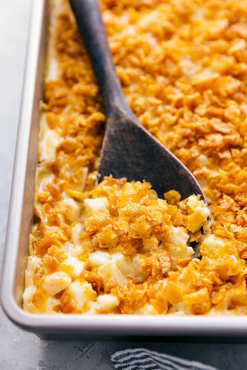 Funeral Potatoes up close and finished with a big wooden spoon serving them up