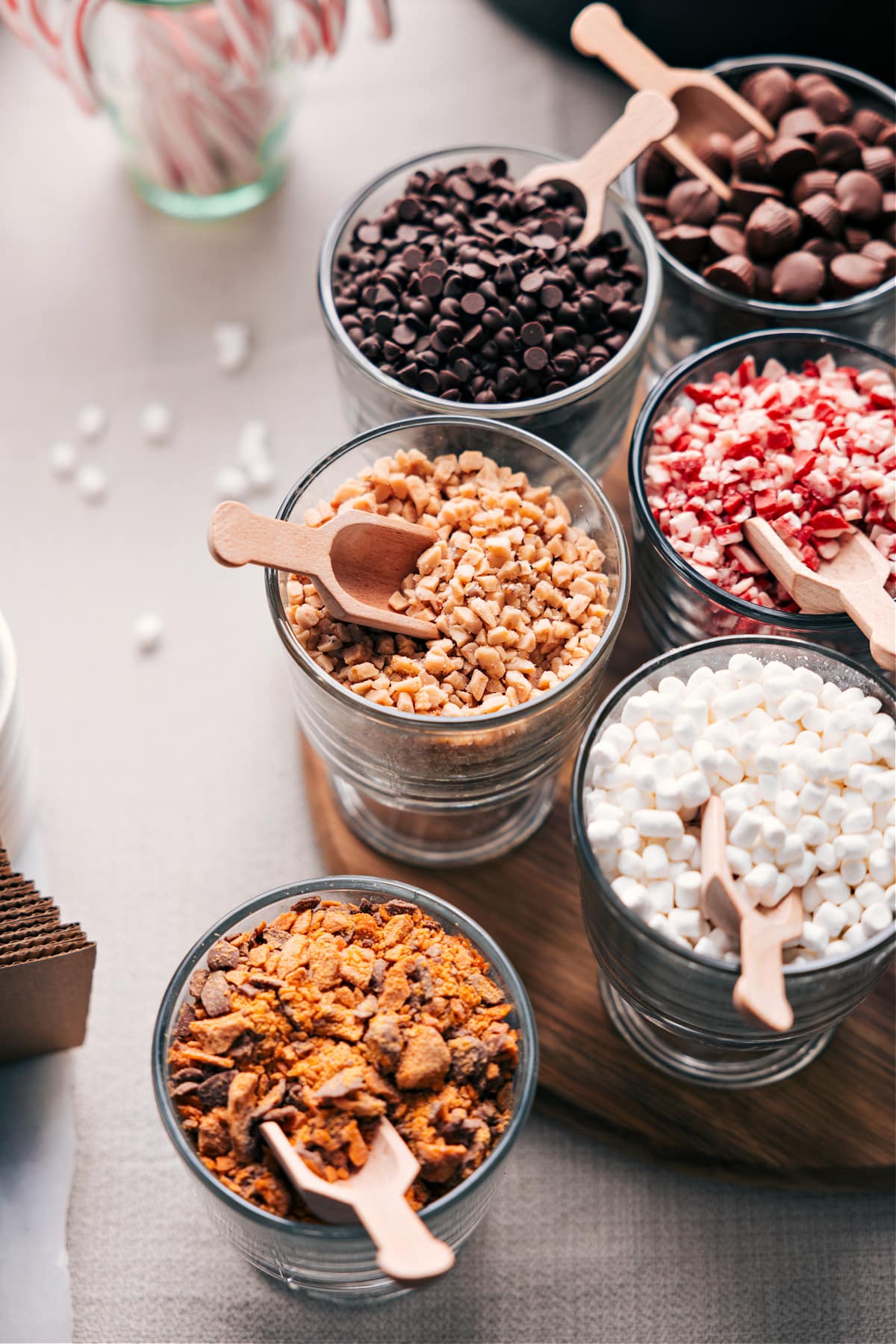 Variety of toppings in containers, each accompanied by a small scoop.