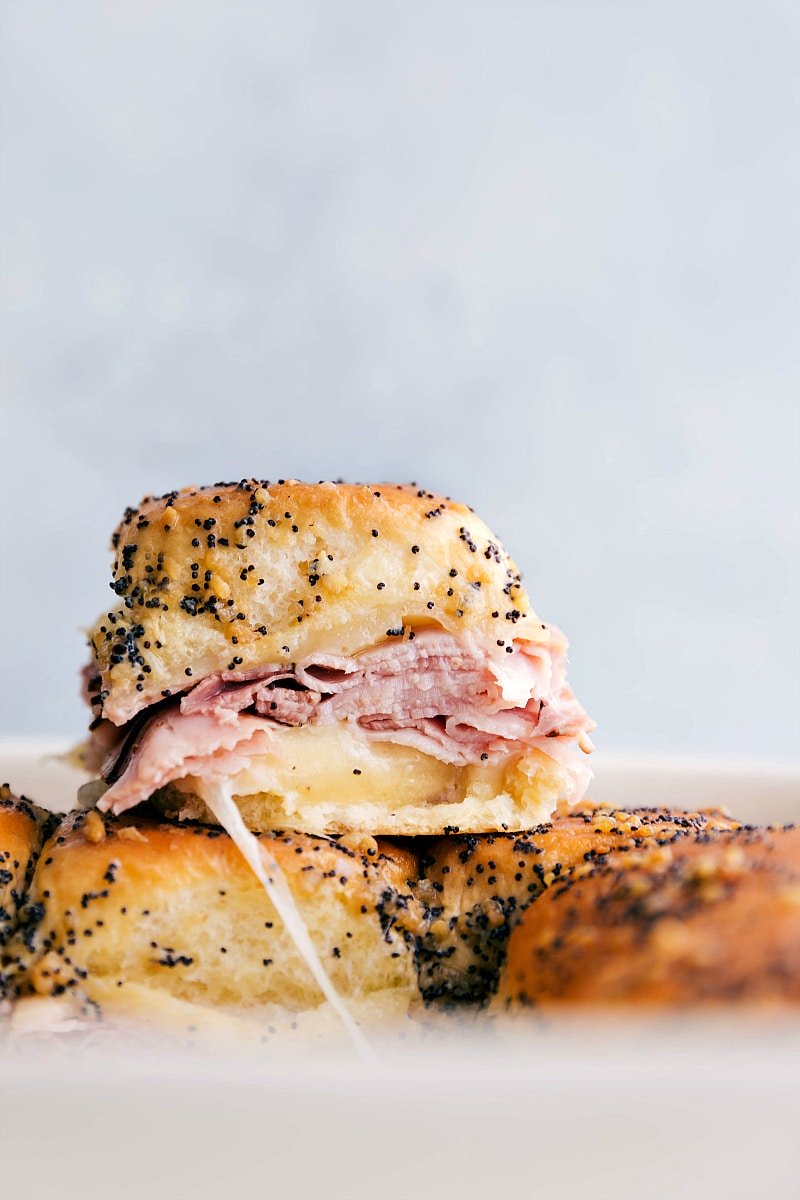 Close-up image of Ham and Cheese Sliders stacked on top of each other.