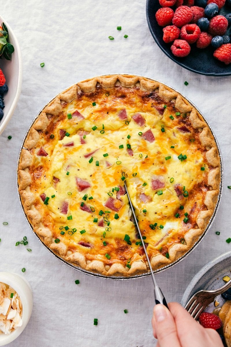 Hearty ham and cheese quiche being sliced to serve.