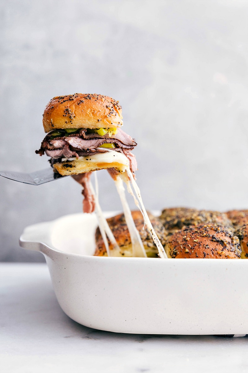 Italian Beef Slider being pulled out a pan with cheese pulls